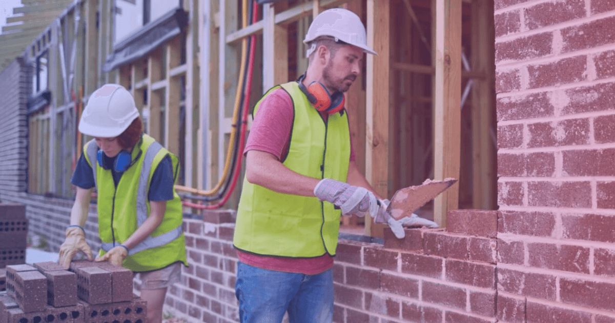 Bricklayer laying bricks on a construction wall