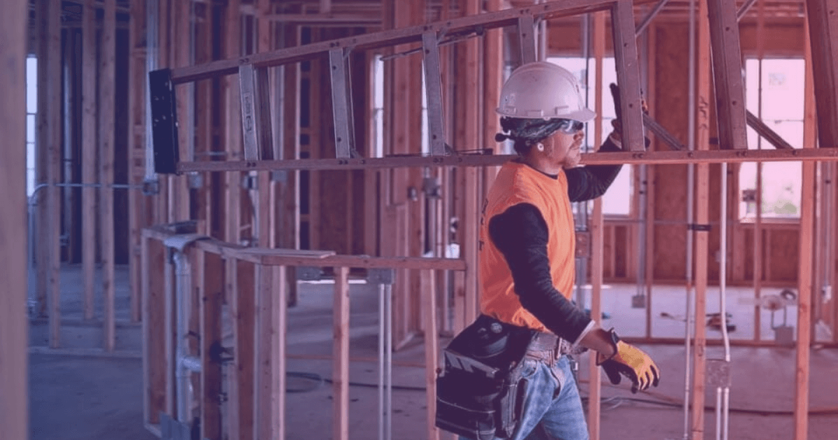 Builder surveying construction site with clipboard