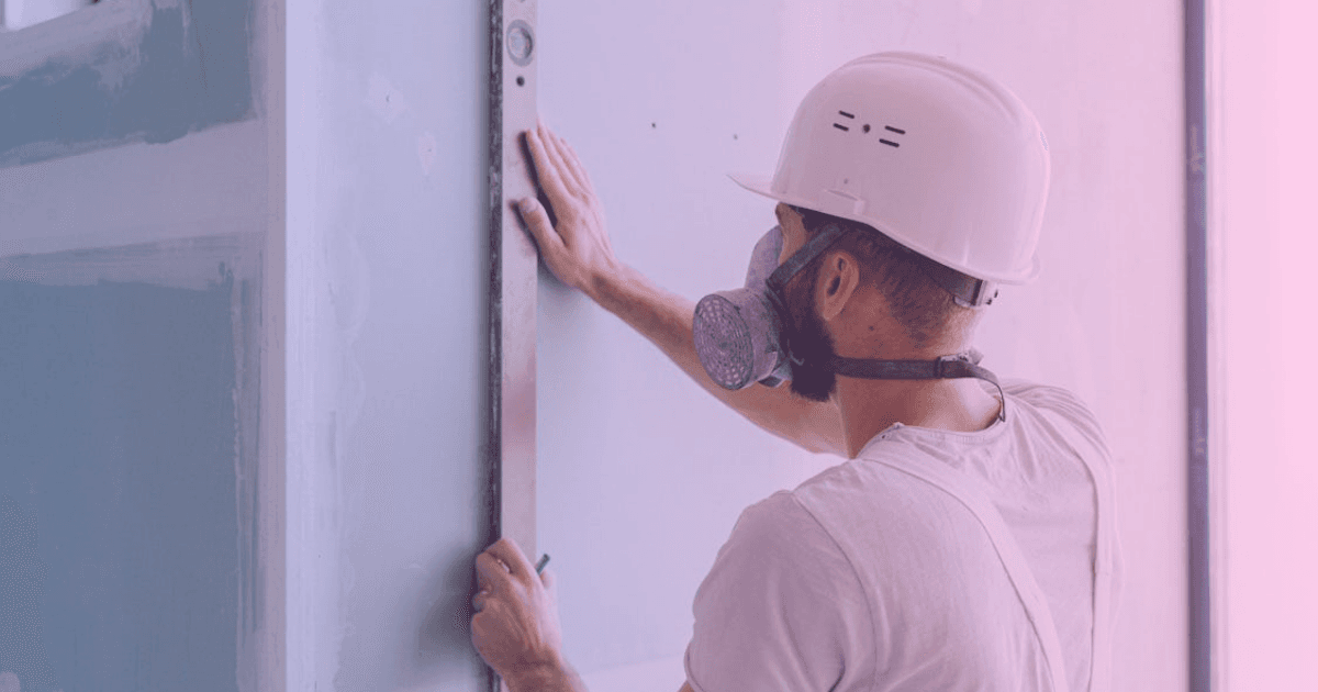 Drywaller applying drywall boards to wall frame