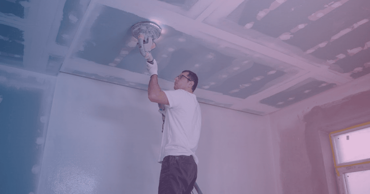 Painter applying paint to interior wall