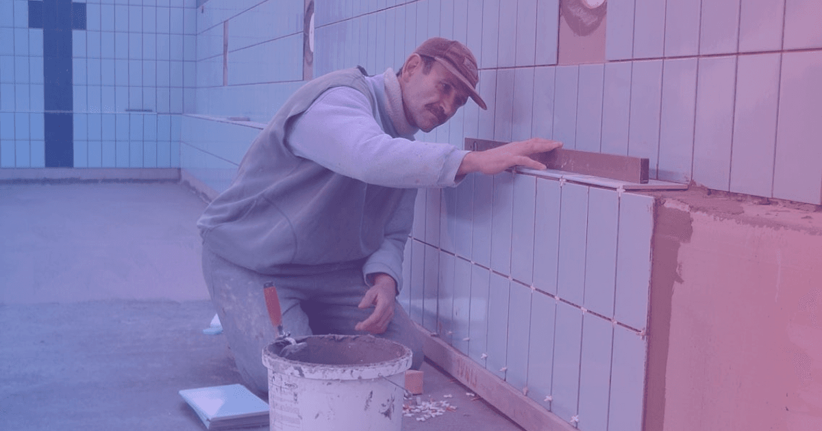 Tiler installing floor tiles with precision